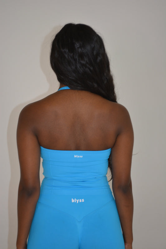 Girl standing in front of a white wall with a bright blue set on