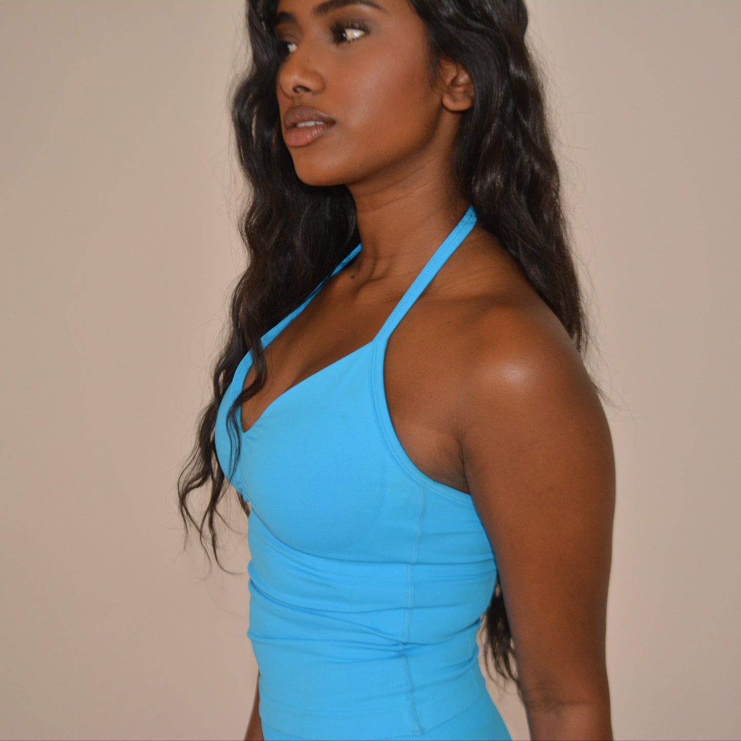 Girl standing in front of a white wall with a bright blue set on