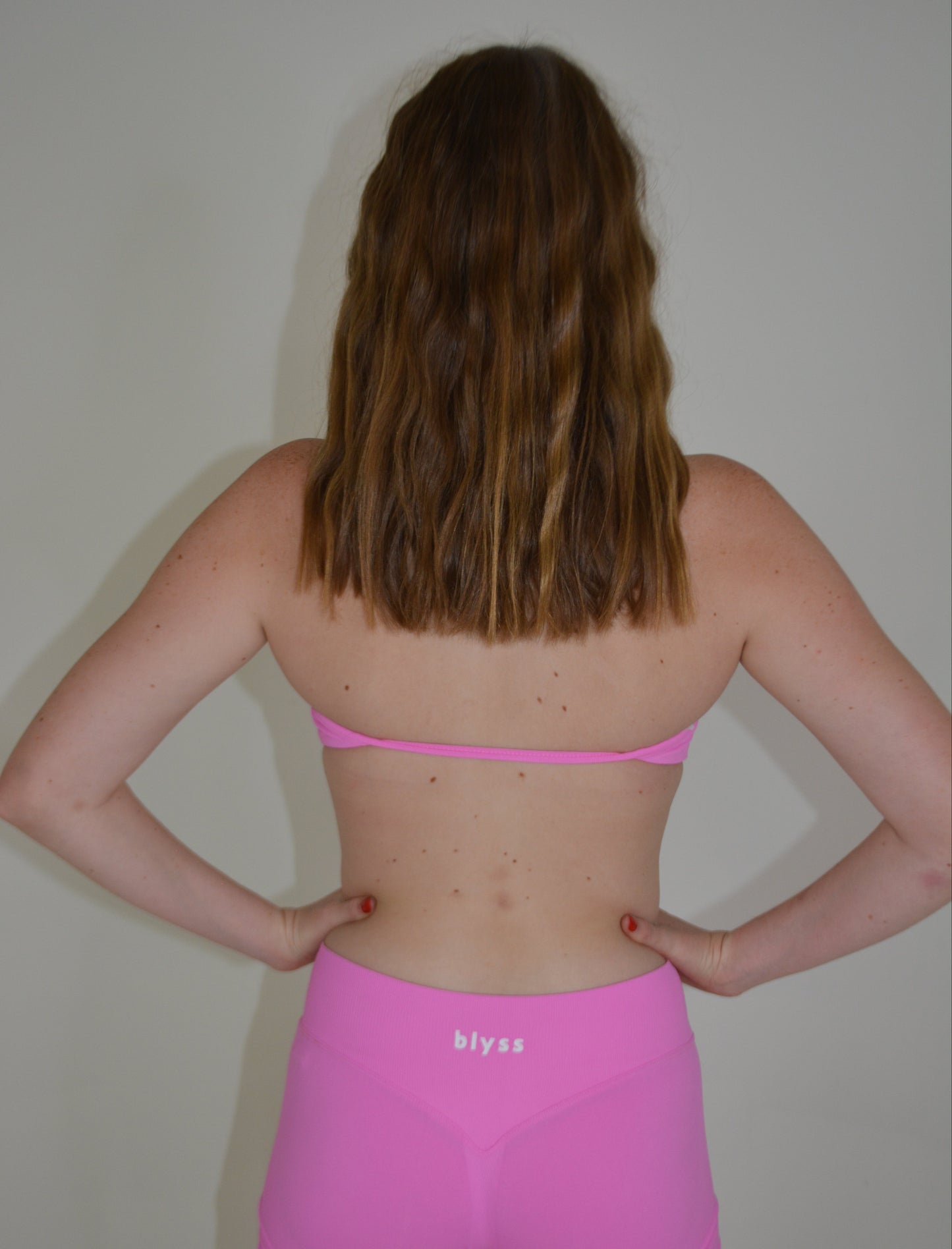 Person wearing a bright pink activewear set against a plain background