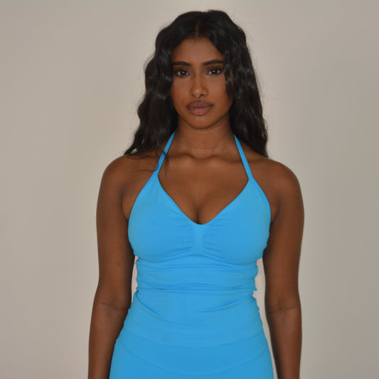 Girl standing in front of a white wall with a bright blue set on