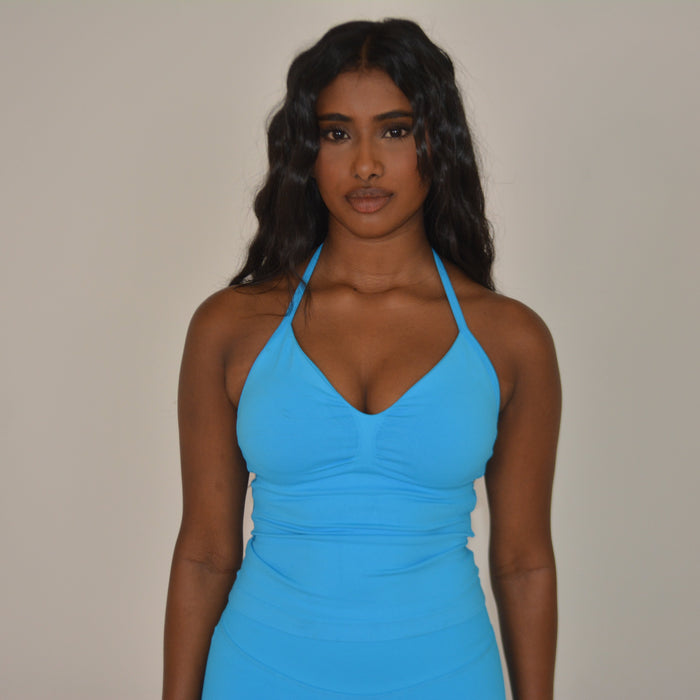 Girl standing in front of a white wall with a bright blue set on