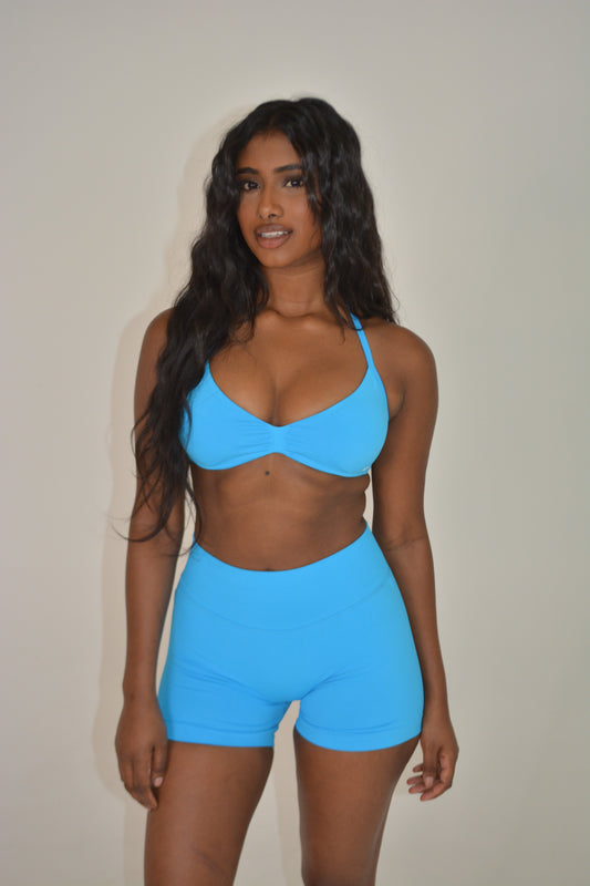 Person wearing a bright blue activewear set against a plain background