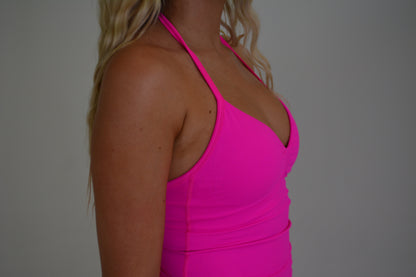 Girl standing in front of a white wall with a bright pink set on