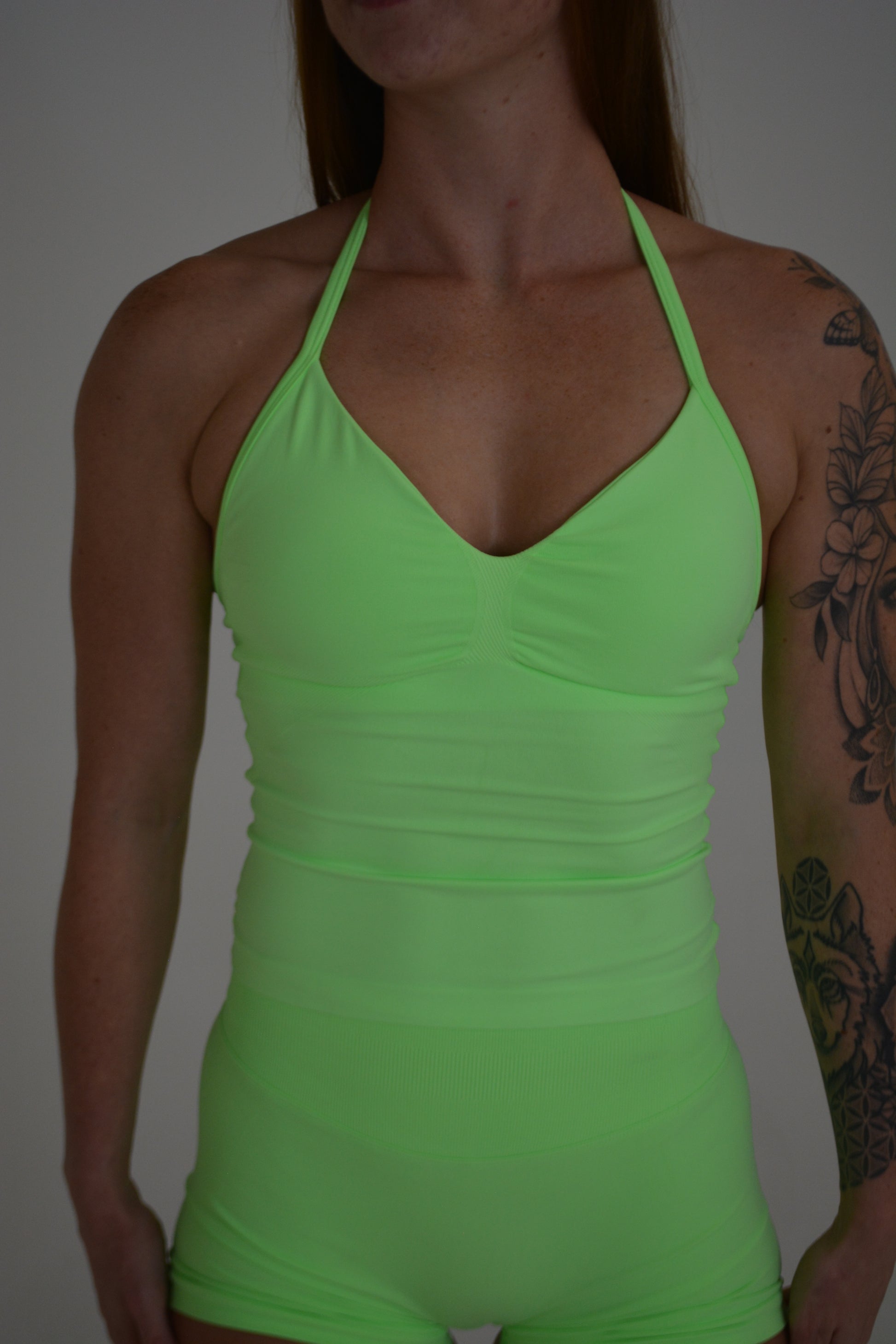 Girl standing in front of a white wall with a bright green set on