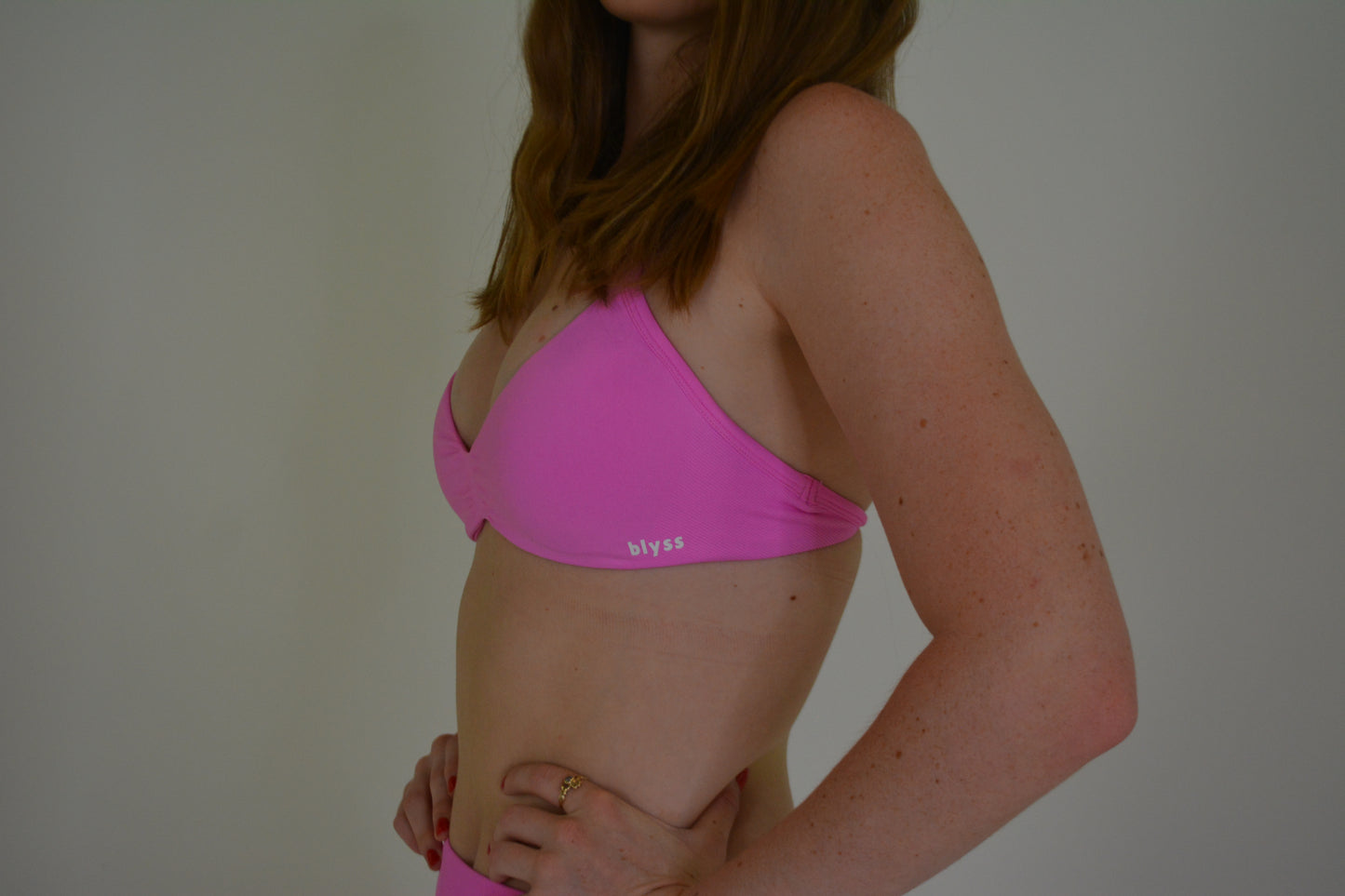 Person wearing a bright pink activewear set against a plain background