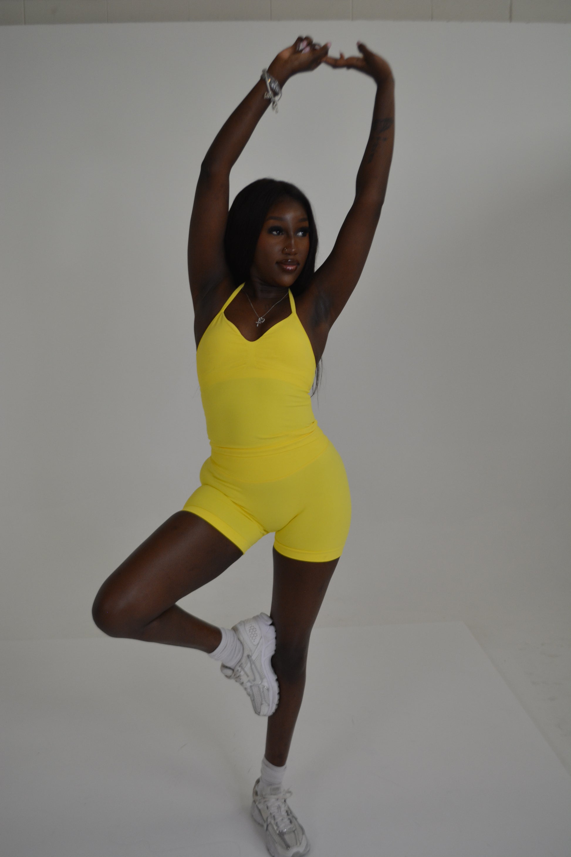 Girl standing in front of a white wall with a bright yellow set on